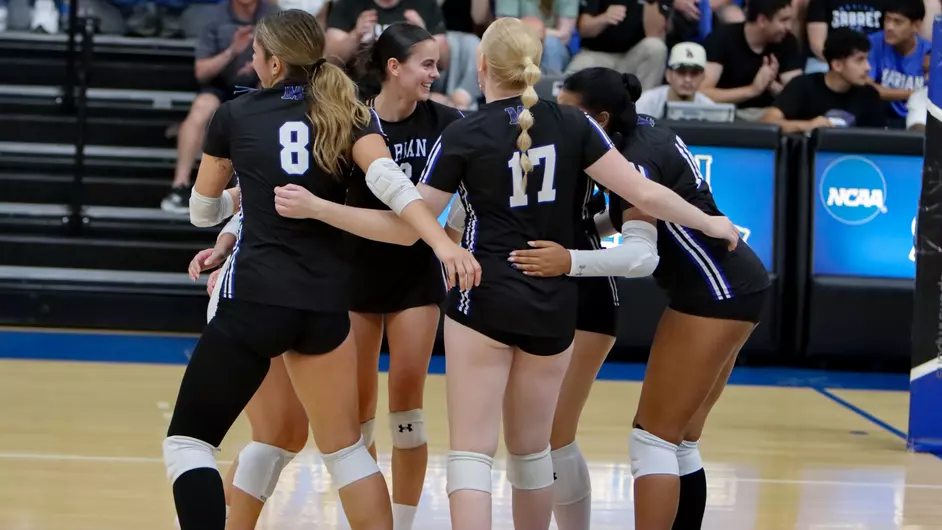 Women playing college volleyball