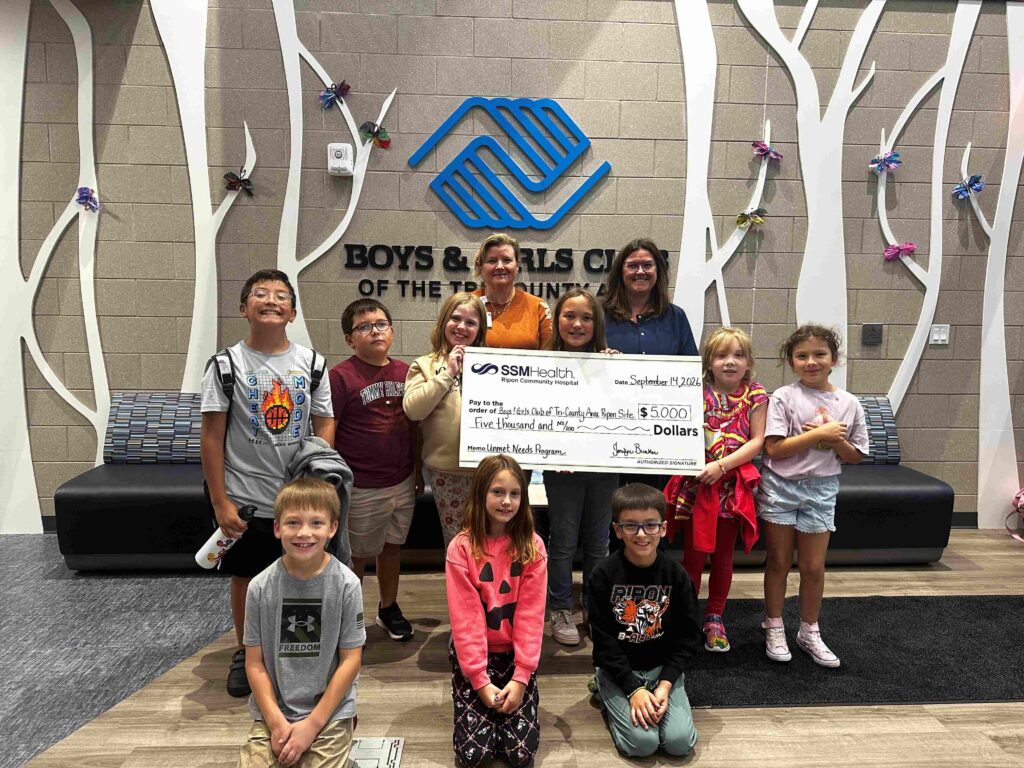 A group of kids holding a big check
