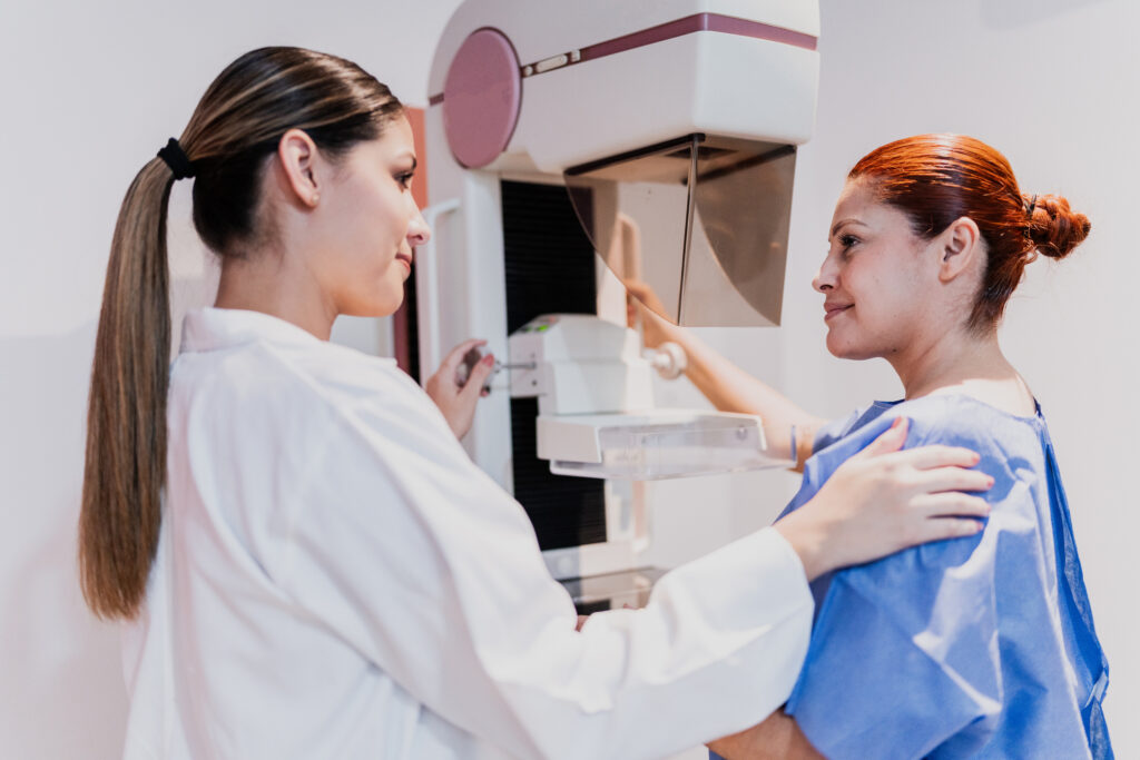 A woman getting a mammogram and a rad tech
