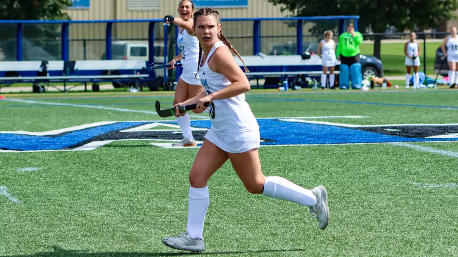 women playing college field hockey