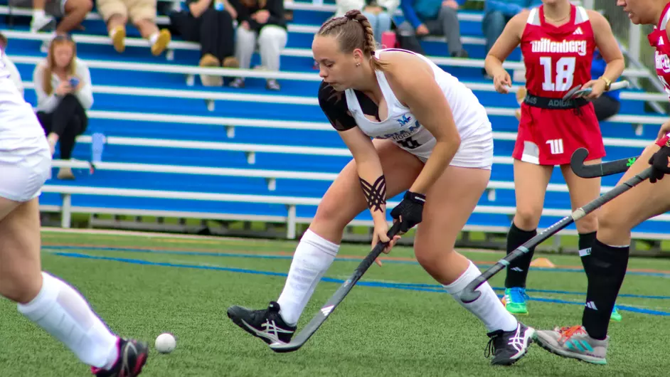 women playing college field hockey