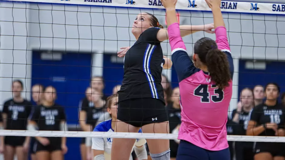 Women playing college volleyball