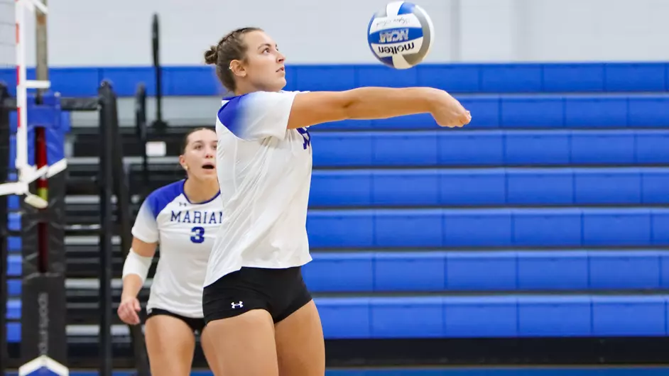 Women playing college volleyball